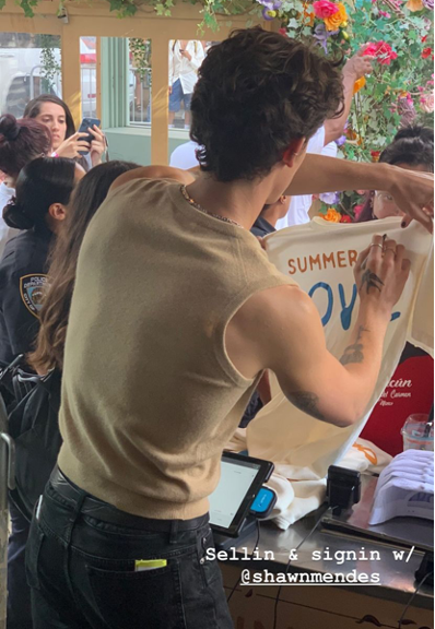 2shawn mendes signing with atenu in background